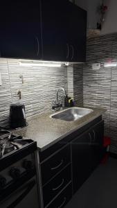 eine Küche mit Spüle und Herd in der Unterkunft EzeApart in Ezeiza + 3 Fotos