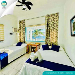 een slaapkamer met twee bedden, een tafel en een raam bij shanedel's inn & café in Basco