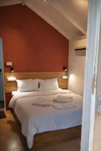 a bedroom with a white bed with a red wall at Sea Shades Palolem Resort in Palolem