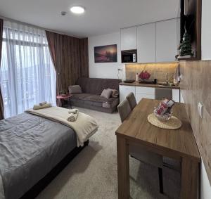a bedroom with a bed and a table and a couch at Monte LUX 10 in Kopaonik