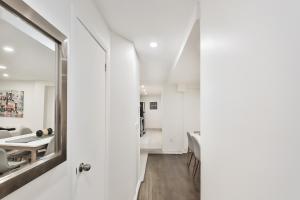 a room with white walls and a mirror at FREE PARKING - In-Suite WASHER & DRYER - fully stocked KITCHEN - WORKSPACE PROVIDED - FAST WIFI - 5 minute walk to the most CENTRAL metro station IN MONTREAL - BERRI UQAM in Montréal +131 photos