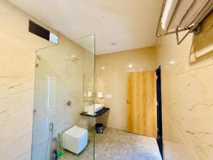 ein Badezimmer mit Glasdusche und Waschbecken in der Unterkunft Green Valley Resort in Mount Ābu + 18 Fotos