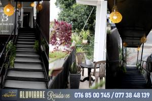 een trap die naar een terras leidt met een tafel en bloemen bij Aluvihare Residence in Matale