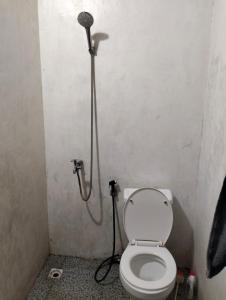 een badkamer met een toilet en een douche bij waroeng bangket in Mantang