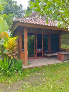 een huis met een veranda met een bankje erop bij waroeng bangket in Mantang