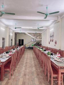 a long banquet hall with long tables and chairs at Hotel Thi Hoa Bai Dinh in Ninh Binh