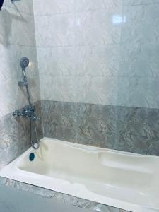 e bagno con vasca bianca e doccia. di Mm inn hotel 