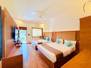 ein Hotelzimmer mit 2 Betten und blauen Kissen in der Unterkunft Green Valley Resort in Mount Ābu