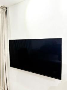 a flat screen tv hanging on a wall at Sunset Sky Nest CBD 65F in Melbourne
