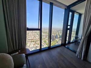 a living room with large windows and a view of a city at Sunset Sky Nest CBD 65F in Melbourne