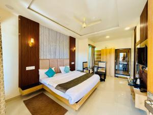 ein Schlafzimmer mit einem großen Bett und blauen Kissen in der Unterkunft Green Valley Resort in Mount Ābu