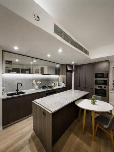 a kitchen with a counter and a table at Sunset Sky Nest CBD 65F in Melbourne