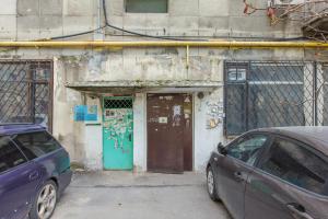 two cars parked in front of a building with a door at Гоголя 117 in Almaty