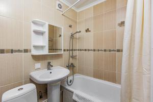 a bathroom with a sink and a toilet and a bath tub at Гоголя 117 in Almaty +17 photos