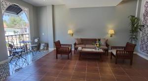 a living room with a couch and chairs and a table at Thong Prachok Hotel in Sakon Nakhon