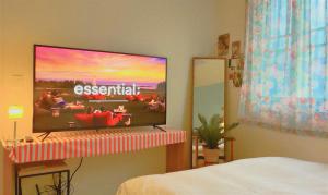 een flatscreen-tv aan een muur in een slaapkamer bij The Cozy Oven in Busan +22 foto's