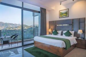 a bedroom with a large bed and a balcony at Silver wings Kasauli in Kasauli