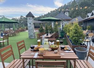 a wooden table with food and wine on a patio at Silver wings Kasauli in Kasauli