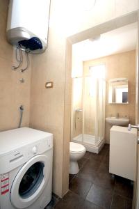 a bathroom with a washing machine and a toilet at Apartments Drašković Mirišta in Petrovac na Moru