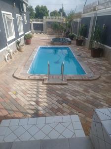 - une piscine avec deux robinets dans un jardin dans l'établissement Gold Crown International Hotel Johannesburg, à Johannesbourg