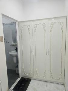 a white cabinet with two doors in a bathroom at Ruby Hotel Front Of Beach 2 in Bình Sum