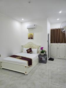 a bedroom with a large white bed in a room at Ruby Hotel Front Of Beach 2 in Bình Sum