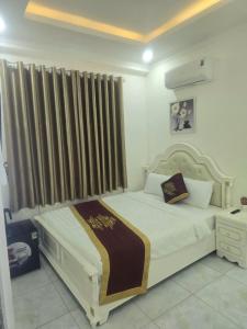 a bedroom with a large white bed with a window at Ruby Hotel Front Of Beach 2 in Bình Sum +38 photos