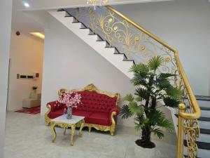 a living room with a red couch and a staircase at Ruby Hotel Front Of Beach 2 in Bình Sum