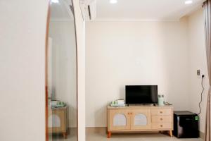 a mirror in a room with a television on a dresser at The Sky Homestay in Ấp Khánh Phước (1) +25 photos