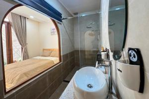 a bathroom with a sink and a bed and a mirror at The Sky Homestay in Ấp Khánh Phước (1)