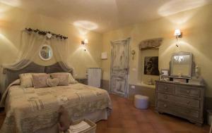 sypialnia z łóżkiem, komodą i lustrem w obiekcie Agriturismo Poggio Alle Serre w mieście Gallinaro