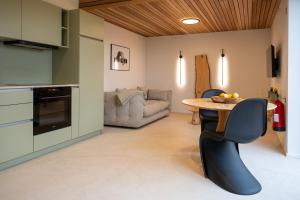 a kitchen and living room with a table and chairs at Le Marzelheide 3 in Lontzen