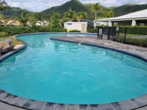 a large pool with blue water in a yard at Villa 46 in Pauanui