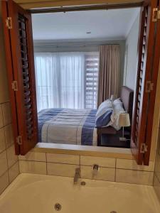 ein Badezimmer mit einem großen Spiegel über der Badewanne in der Unterkunft Villa 46 in Pauanui