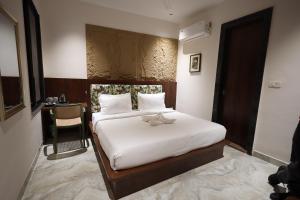 een slaapkamer met een bed met een teddybeer erop bij Hotel Destin in Gwalior