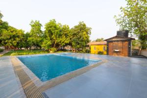 a swimming pool in a yard with a building at Glory of MJ, Family Resort in Nature, Panvel in Panvel