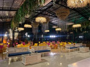 a large room with tables and chairs and chandeliers at The Aralia in Dehradun +39 photos