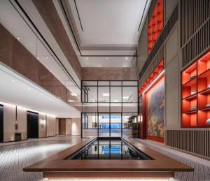 eine Lobby mit einem Pool in der Mitte eines Gebäudes in der Unterkunft Mumian Rizhao Hotel in Rizhao