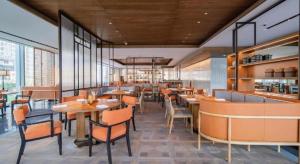 ein Restaurant mit Tischen und Stühlen in einem Raum in der Unterkunft Mumian Rizhao Hotel in Rizhao