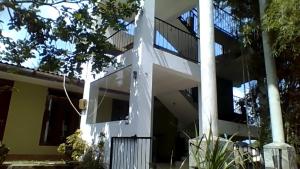a white building with a staircase in front of it at Green Wood Range in Kandy