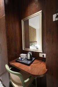 een tafel met een spiegel en een waterkoker erop bij Hotel Destin in Gwalior