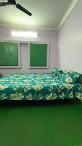a bedroom with a bed with a green comforter at Awadh homestay in Varanasi