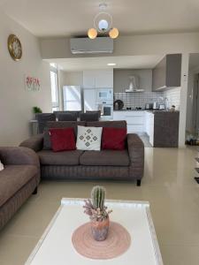 a living room with a couch and a cactus in the middle at Sea Breeze Suites by the Coast in Iskele