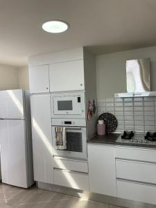a kitchen with white cabinets and a white refrigerator at Sea Breeze Suites by the Coast in Iskele