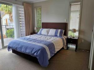 ein Schlafzimmer mit einem großen Bett und einem Fenster in der Unterkunft Villa 46 in Pauanui + 24 Fotos