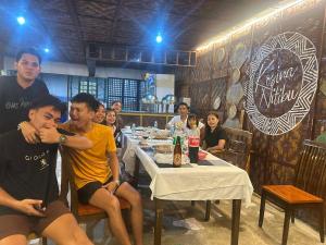 a group of people sitting at a table in a restaurant at Golden palm rise resort in Libaong