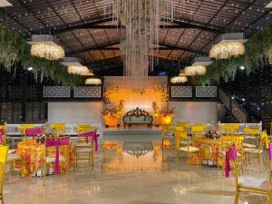 a banquet hall with yellow and purple tables and chairs at The Aralia in Dehradun