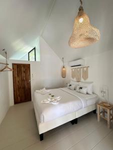 a bedroom with a white bed and a chandelier at Sama Beach Resort by Munchies Resort in Ban Tai +192 photos