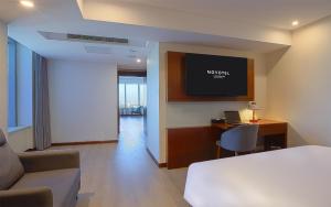 een hotelkamer met een bed en een tv aan de muur bij Novotel Atlantis Shanghai in Shanghai