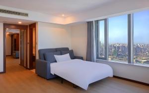 een slaapkamer met een bed en een groot raam bij Novotel Atlantis Shanghai in Shanghai +129 foto's